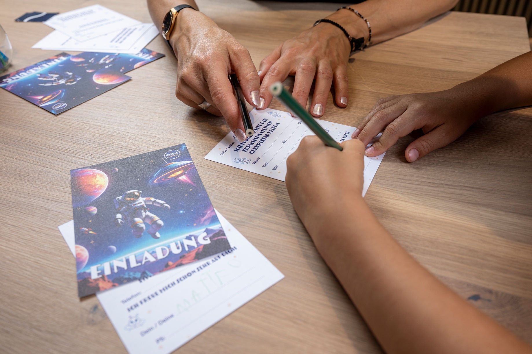 Mutter und Kind schreiben gemeinsam die Astronauten-Einladung