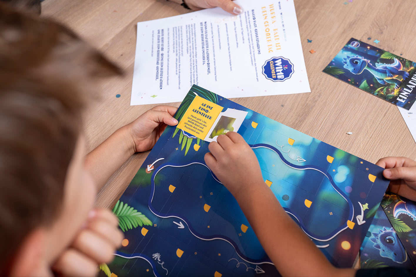 Kind liest gemeinsam mit Elternteil die erste Dino-Aufgabe